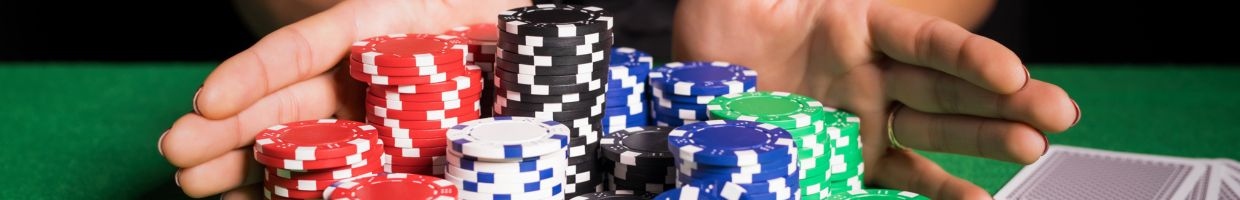Hero image, hands pushing poker chips forward on a green felt poker surface with playing cards on the side
